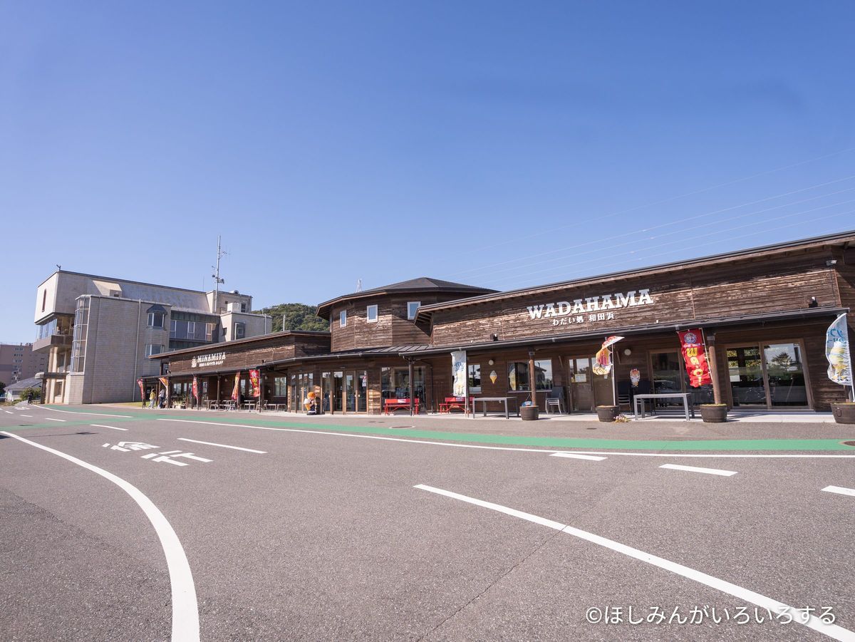 道の駅 和田浦 WA・O!の建物。黒い木の壁に「WADAHAMA」の看板