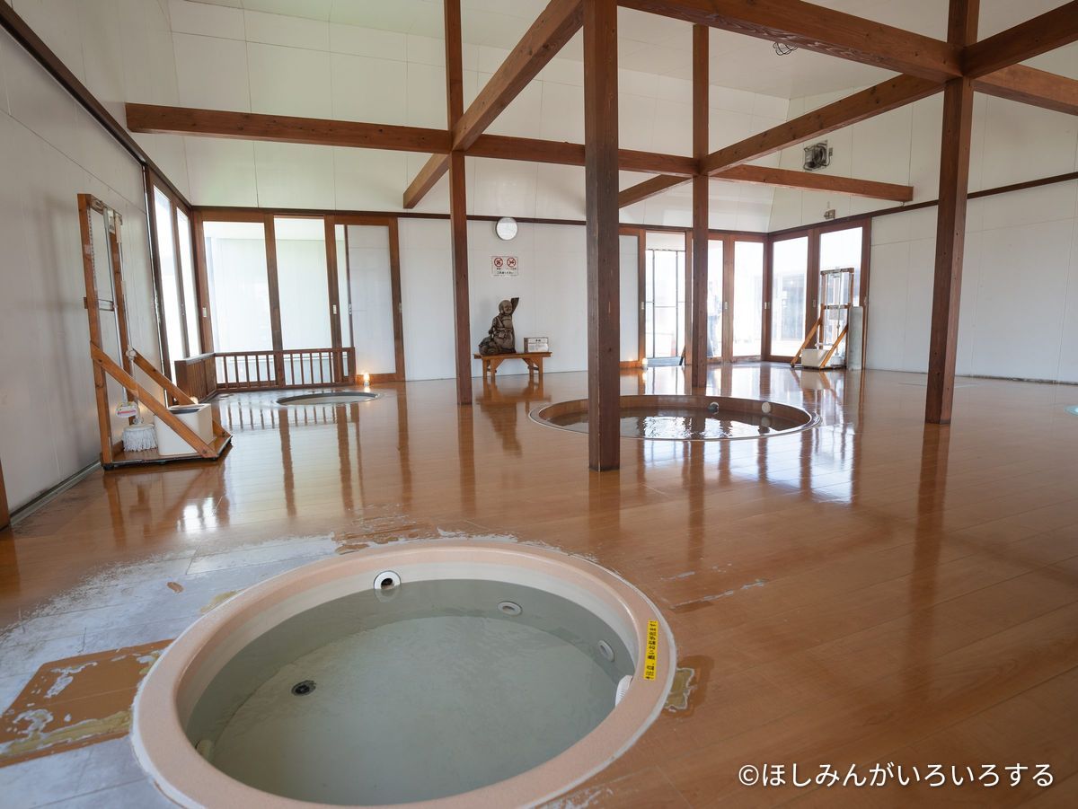 屋内の足湯。木の床に丸い湯船